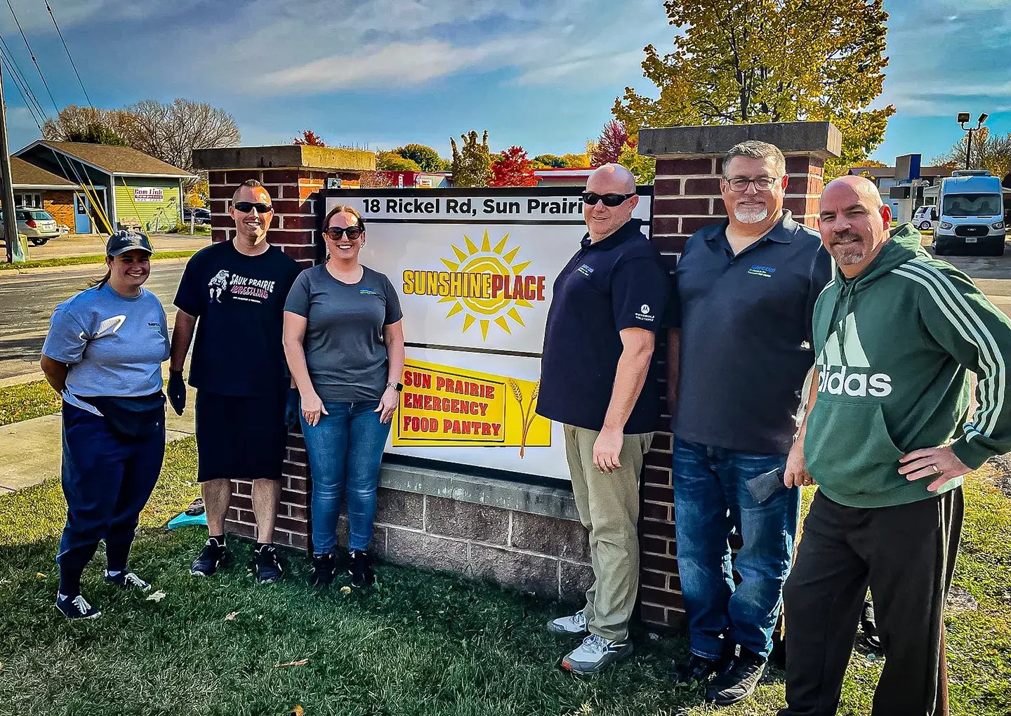 people-posing-by-sunshineplace-sign