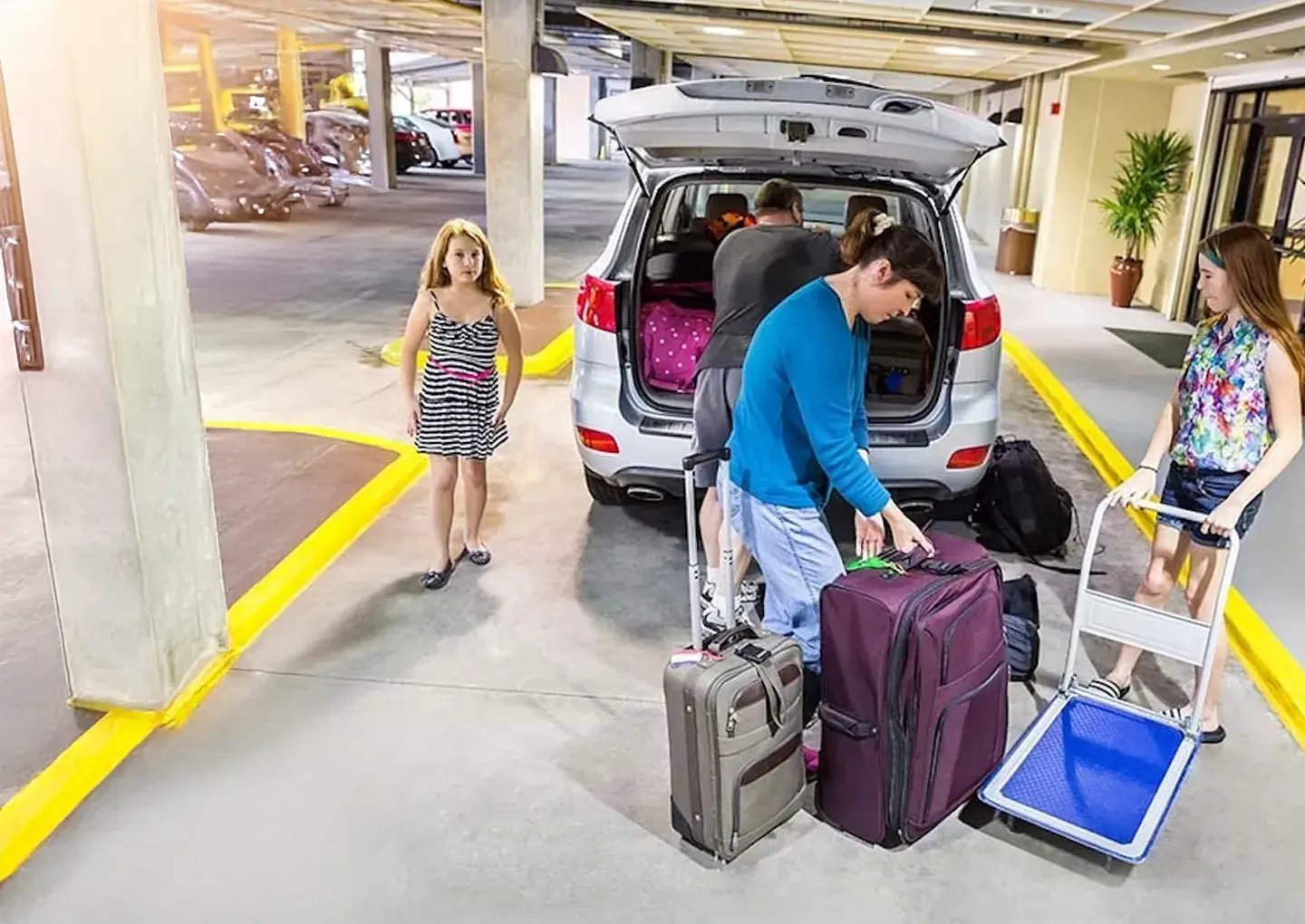 family-unloading-luggage-from-car