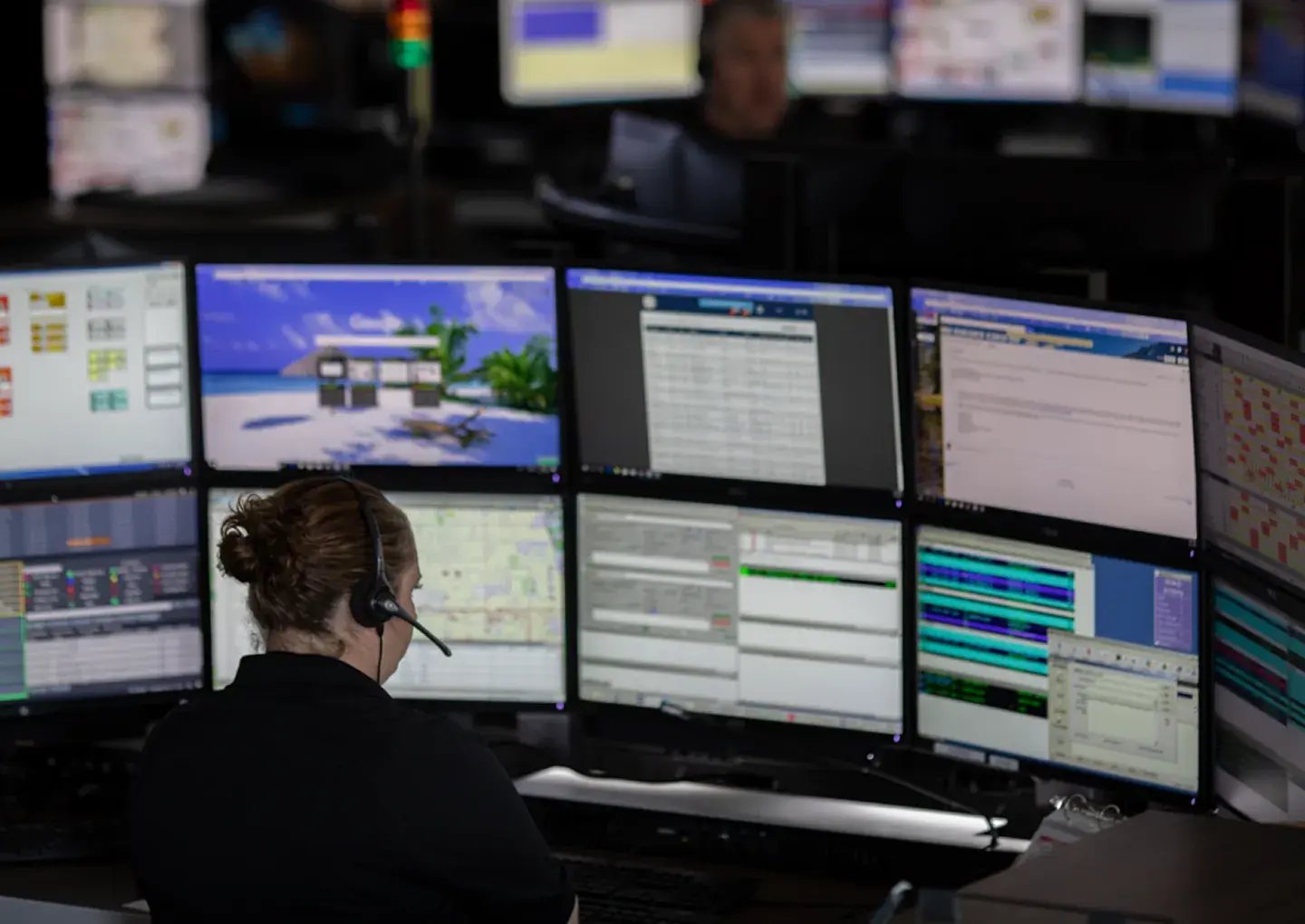 woman-with-headset-in-front-of-many-screens