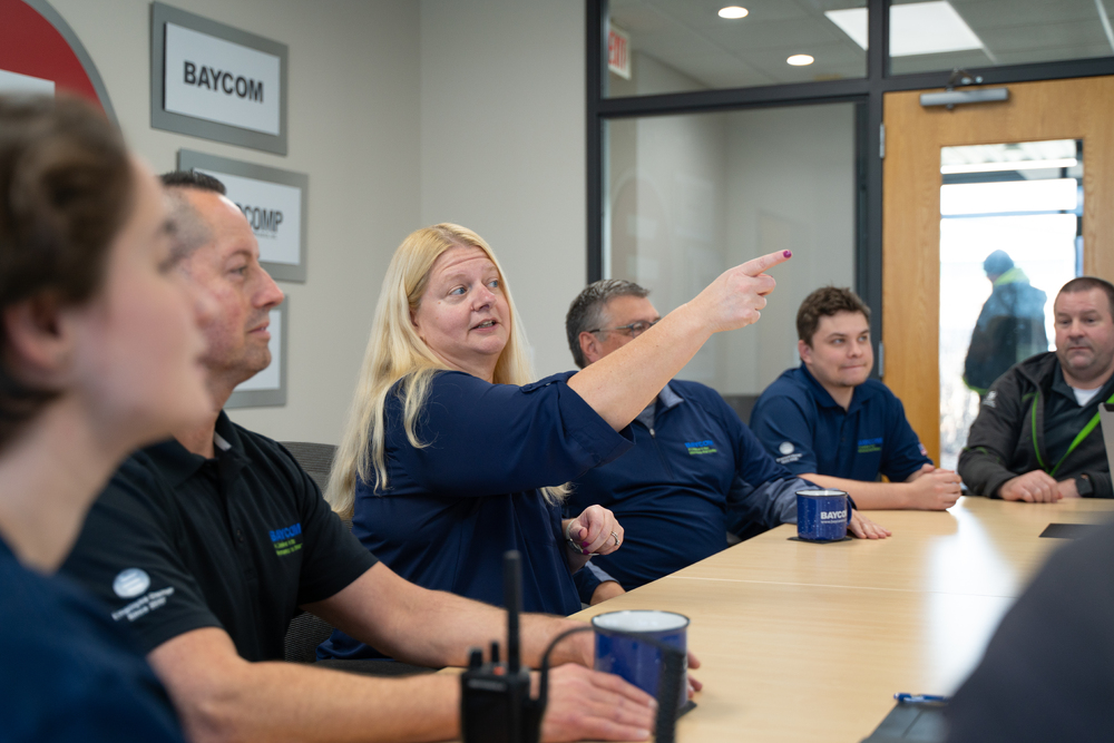 Katie Miner discussing to BAYCOM group at conference room table